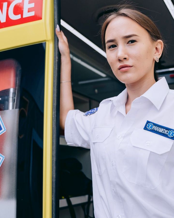 Ambulancière devant la porte d'une ambulance